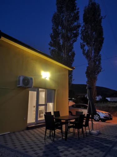 a patio with a table and chairs in front of a building at Žuta kuća in Grude
