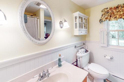 a bathroom with a sink and a toilet and a mirror at Falmouth Beachtown Getaway in Falmouth