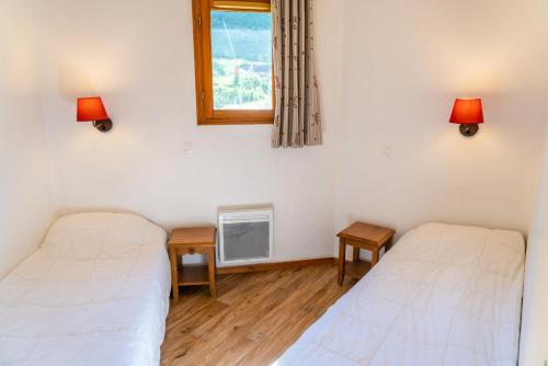 deux lits dans une chambre avec une fenêtre et deux lampes dans l'établissement Résidence Les Hauts De Preclaux - Appartement avec balcon ensoleillé face aux pistes MAE-7061, aux Orres