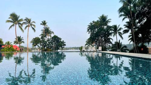 a large swimming pool with palm trees in the background at Nanajuana Río Dulce in Rio Dulce