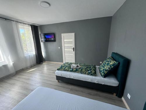 a bedroom with a couch and a television in a room at Guben Wohnungen studio in Guben