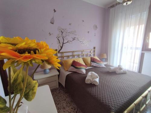 a bedroom with a bed and a vase with a sunflower at Juventus Stadium-Torino, La Mandria-Giardini Reali in Turin