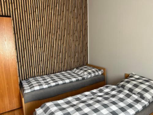 two twin beds in a room with a wall at Tanie Noclegi Puszkina 6 in Wałbrzych