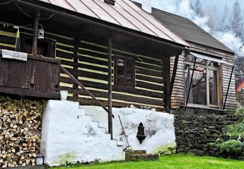 ein altes Haus mit einer Treppe davor in der Unterkunft Cozy Cottage in Staré Hory