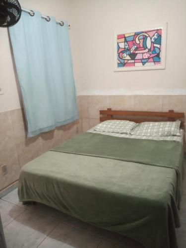 a bedroom with a bed with a blue curtain at Residencial Barbosa - Apto 102 in Macaé