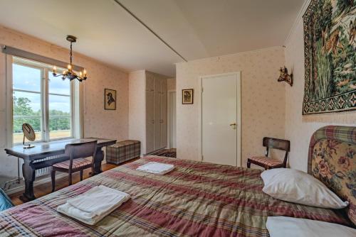 a bedroom with a bed and a desk and a window at Svaneholm Hotel in Svanskog