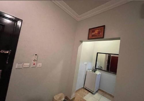 a bathroom with a refrigerator and a mirror on the wall at السارية in Jeddah