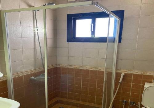 a bathroom with a shower with a toilet and a window at السارية in Jeddah