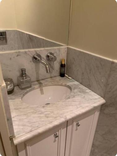 La salle de bains est pourvue d'un lavabo et d'un comptoir en marbre. dans l'établissement Studio Paris 7e Tour Eiffel, à Paris