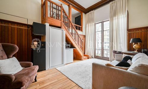 un salon avec un canapé et un escalier dans l'établissement Studio Paris 7e Tour Eiffel, à Paris