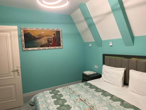 a bedroom with a bed and a painting on the wall at Quba Aframe Mesə & Gol in İkinci Nügǝdi
