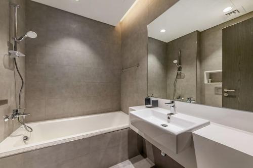 a bathroom with a sink and a bath tub and a sink at Aesthetic 1Br Chrystal Lagoon in Dubai