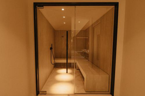 a bathroom with a glass door with a walk in shower at Aethos Saragano in Saragano