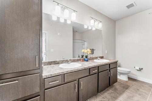 a bathroom with two sinks and a large mirror at Prime SoCo King Bed 1BR & 2BR Suites w Gym, Pickleball, Laundry in Austin