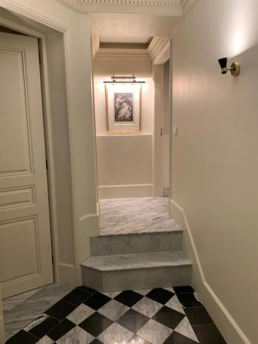 un couloir avec des escaliers et une photo sur le mur dans l'établissement Appartement Tour Eiffel Invalides 7e G, à Paris