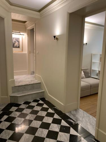 un couloir avec un sol en damier et un salon dans l'établissement Appartement Tour Eiffel Invalides 7e G, à Paris