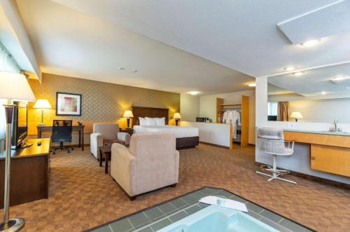 a hotel room with a bed and a bath tub at Prestige Riverside Lodge Quesnel in Quesnel