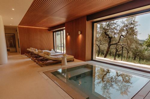 a living room with a large window and a pool at Aethos Saragano in Saragano
