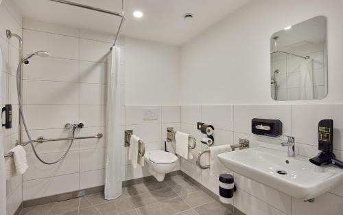 a white bathroom with a toilet and a sink at Trip Inn Hotel Frankfurt-Heusenstamm Tagungshotel in Heusenstamm