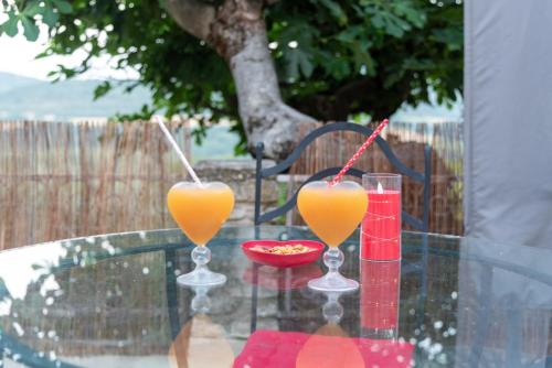 two glasses of orange juice sitting on a glass table at Gite au nid d'Ange in Lincel