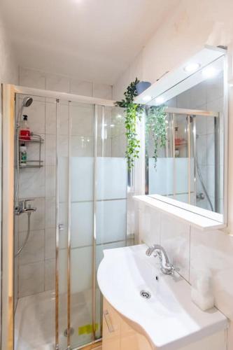 a bathroom with a shower and a sink and a mirror at Charming studio with reading nook & city view in Nicosia
