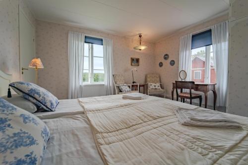 a bedroom with a large bed in a room with windows at Svaneholm Hotel in Svanskog