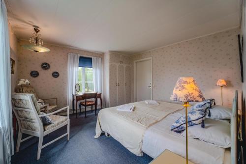 a bedroom with a bed and a desk and a chair at Svaneholm Hotel in Svanskog