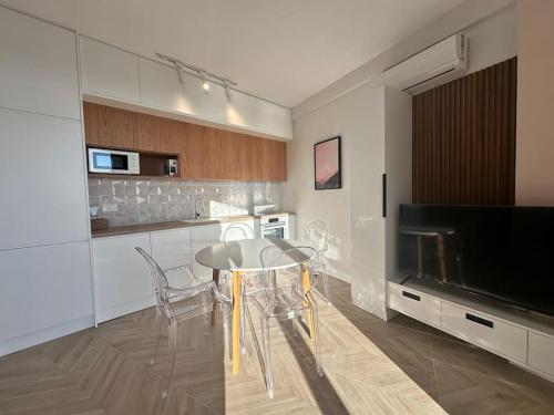 a kitchen with a table and a large television at Vanessa Apartment in Sarandë