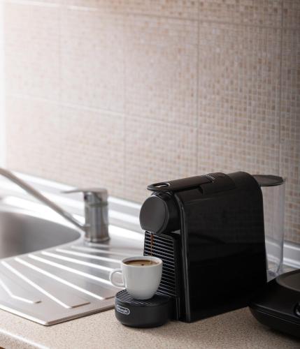 a coffee maker on a counter with a cup of coffee at Agrelia studios in Agios Nikolaos
