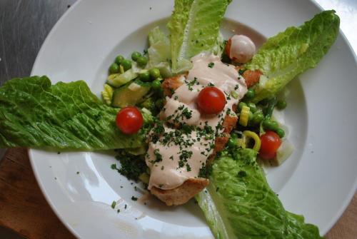 a white plate of food with lettuce and vegetables at Slagsta Motell & Wärdshus in Norsborg