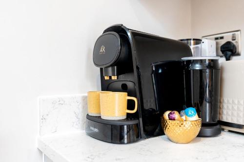 a coffee maker sitting on a counter with a cup of coffee at Exceptional Apartment & Gorgeous Interior & King size bed in Leeds