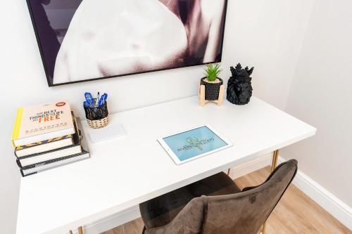 a white desk with a chair and a painting at Exceptional Apartment & Gorgeous Interior & King size bed in Leeds