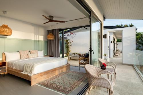 Twin Villas Natai - 7 Bedroom Luxury Beach Front Villa في شاطئ ناتاي: غرفة نوم مع سرير وشرفة