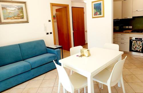 a living room with a blue couch and a white table at I CACTUS di MiMa in Milano Marittima