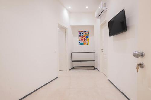 a hallway with white walls and a flat screen tv at Affittacamere Saint Bon 15 - 5 Terre Rooms and Suites in La Spezia