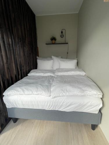 a bed with white sheets and pillows in a bedroom at Modern apartment ONLY 5 minutes from City Centre in Bergen