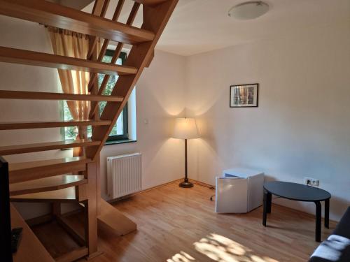 a living room with a staircase and a lamp at Hotel Opat in Kutná Hora