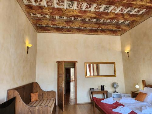 a bedroom with a bed and a couch in a room at Hotel Opat in Kutná Hora