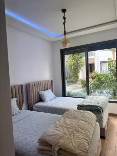 two beds in a room with a blue ceiling at Dar Bouazza getaway in Tamaris