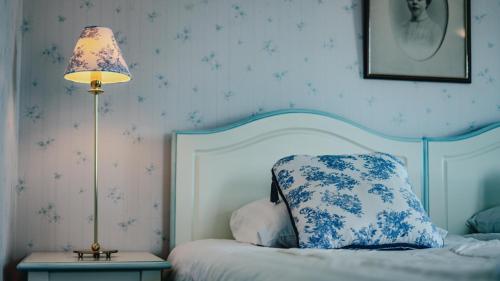 a bedroom with a bed with a pillow and a lamp at Svaneholm Hotel in Svanskog