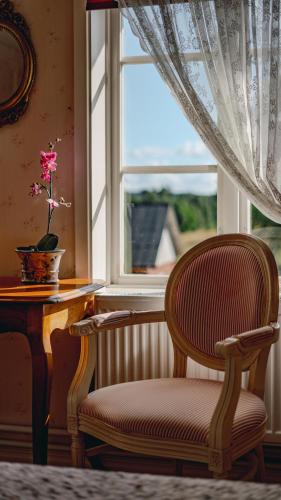 a chair sitting in front of a window at Svaneholm Hotel in Svanskog