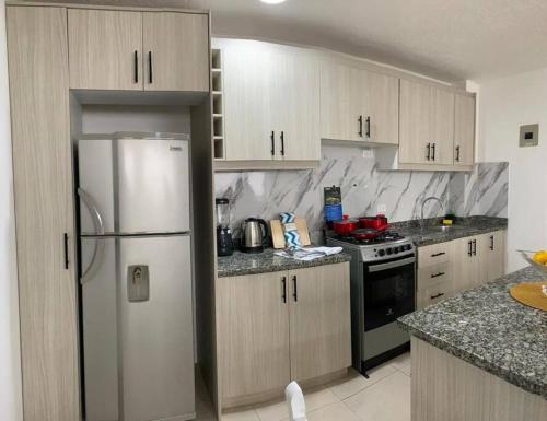 a kitchen with a white refrigerator and a stove at Casa Paraiso Ambato in Ambato