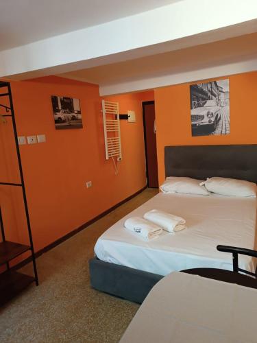 帕尔马APPARTAMENTO CHECK iN的橙色墙壁的房间里有两张床