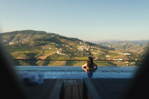 a woman is sitting in a pool of water at Casa da Quebrada, Douro in Lamego