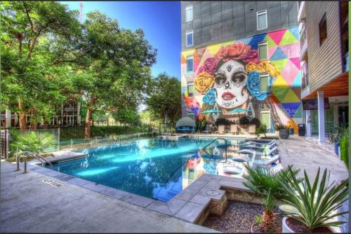 a mural on the side of a building with a pool at Beautiful RiverWalk Apt with Full Amenities, King Bed & Free Parking in San Antonio