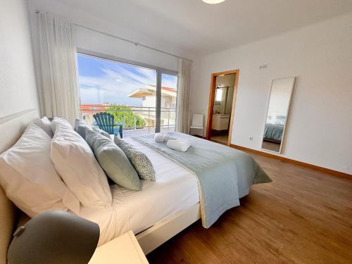a bedroom with a large bed with a large window at Serene View - By SCH in Alvados