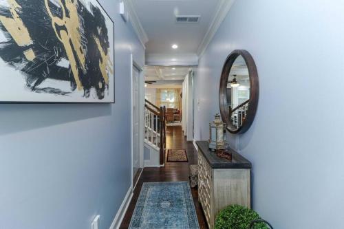 a hallway with blue walls and a mirror on a wall at Luxury Atlanta Home with King Bed and Yard in Lilburn