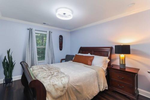 a bedroom with a bed and a table with a lamp at Luxury Atlanta Home with King Bed and Yard in Lilburn