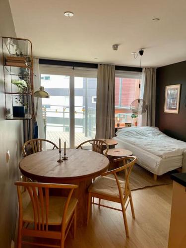 une pièce avec une table, des chaises et un lit dans l'établissement Nordisk moderne leilighet med parkering, à Tomasjorda