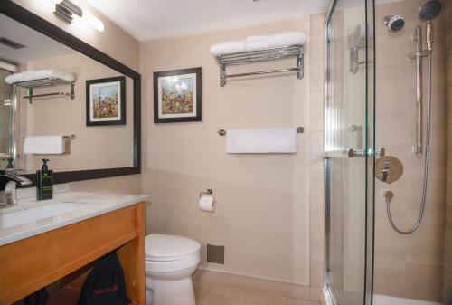 a bathroom with a shower and a toilet and a sink at Coast Hillcrest Hotel in Revelstoke